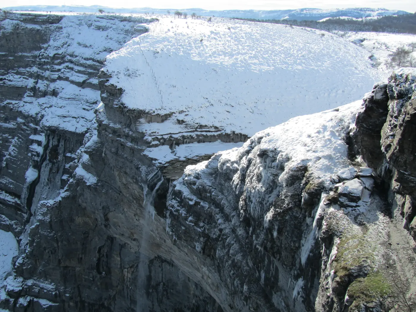 La cascada del Salto del Nervión en invierno rodeada de cortados calizos nevados